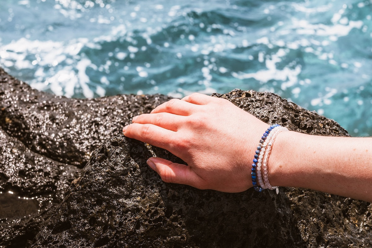 Hand auf Felsen mit Bergkristall Schmuck